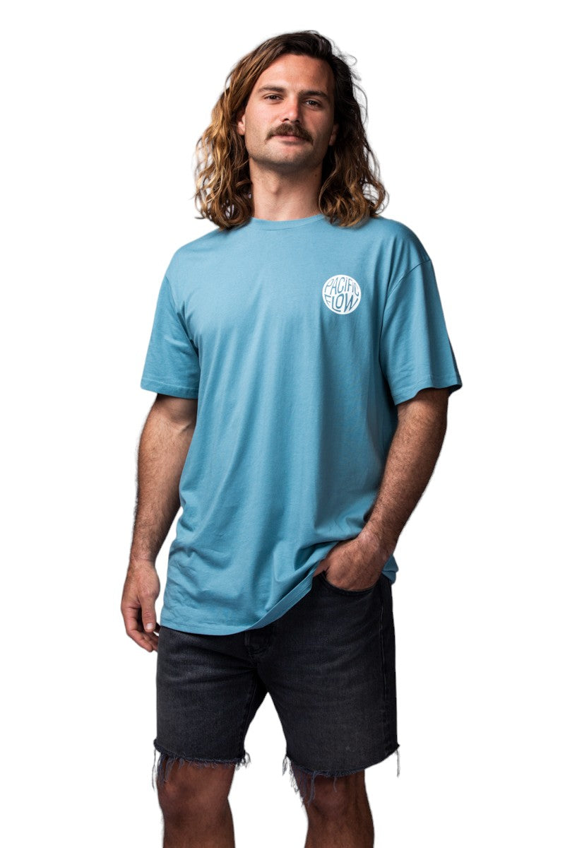 a view of the mountains, the ocean, a surfer and the shipwreck from Byron Bay on a ocean blue shirt